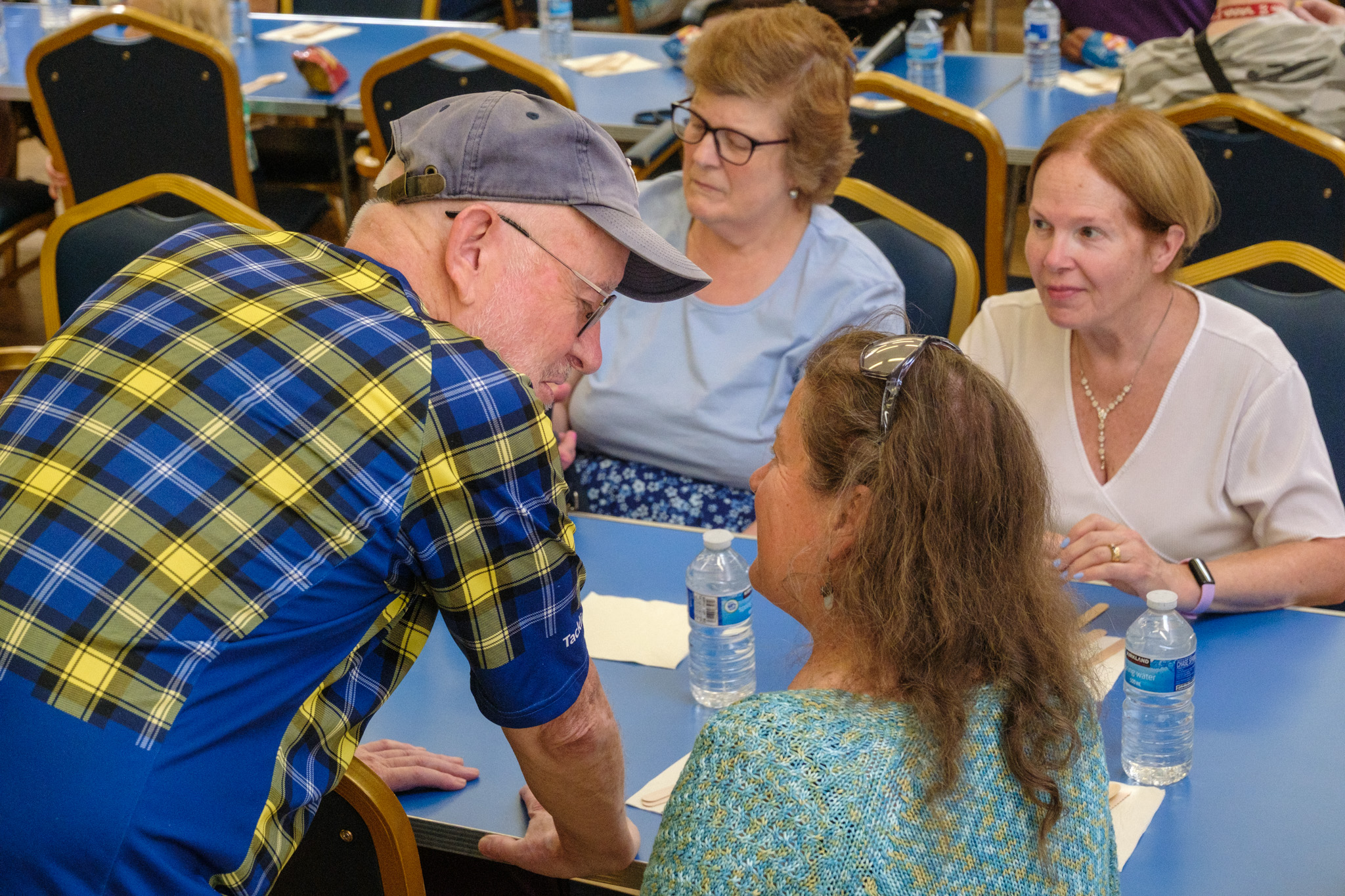 Four guests chatting around a table during the Summer BBQ.
