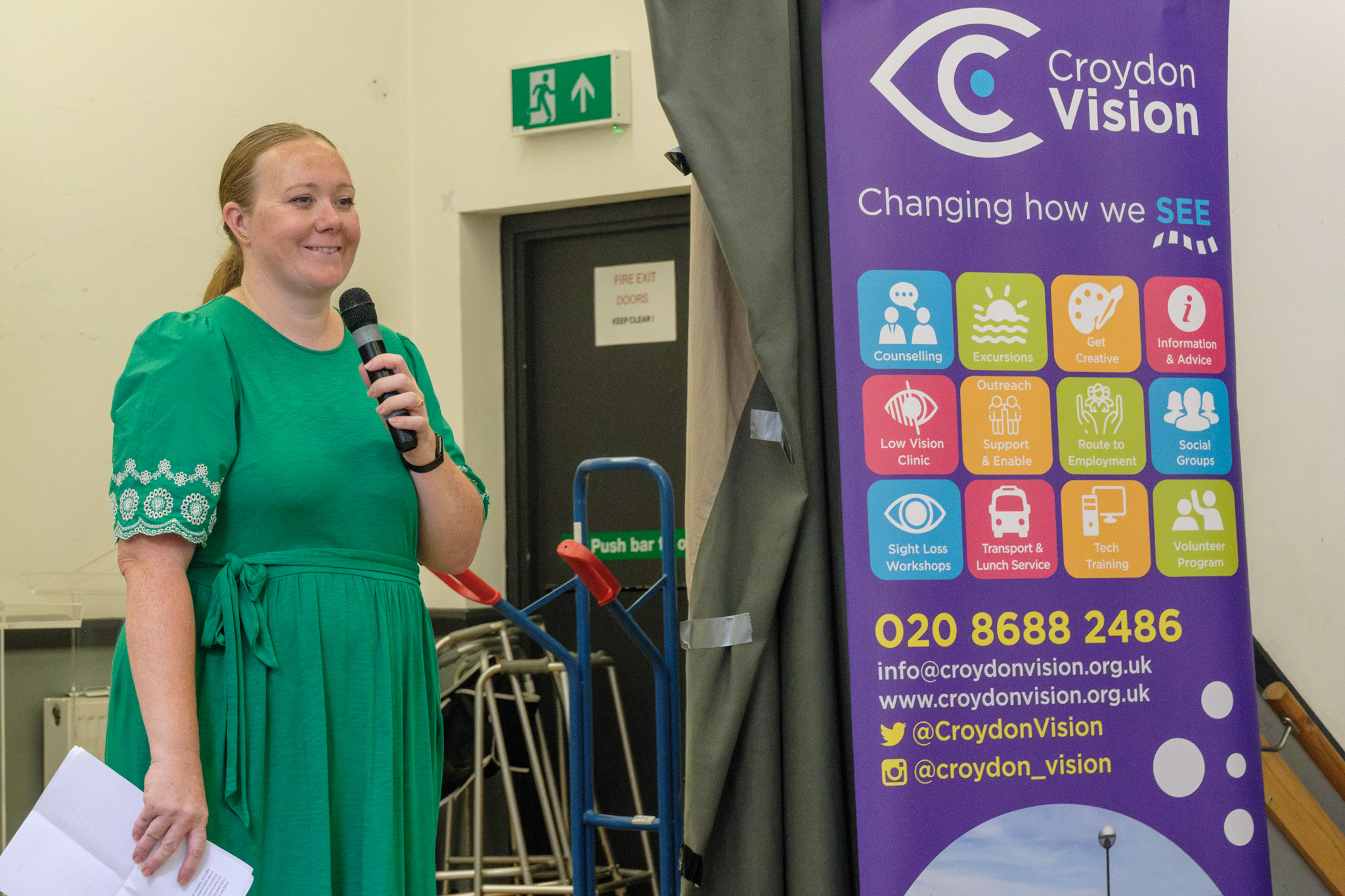 A Croydon Vision representative speaking into a microphone beside a Croydon Vision banner.
