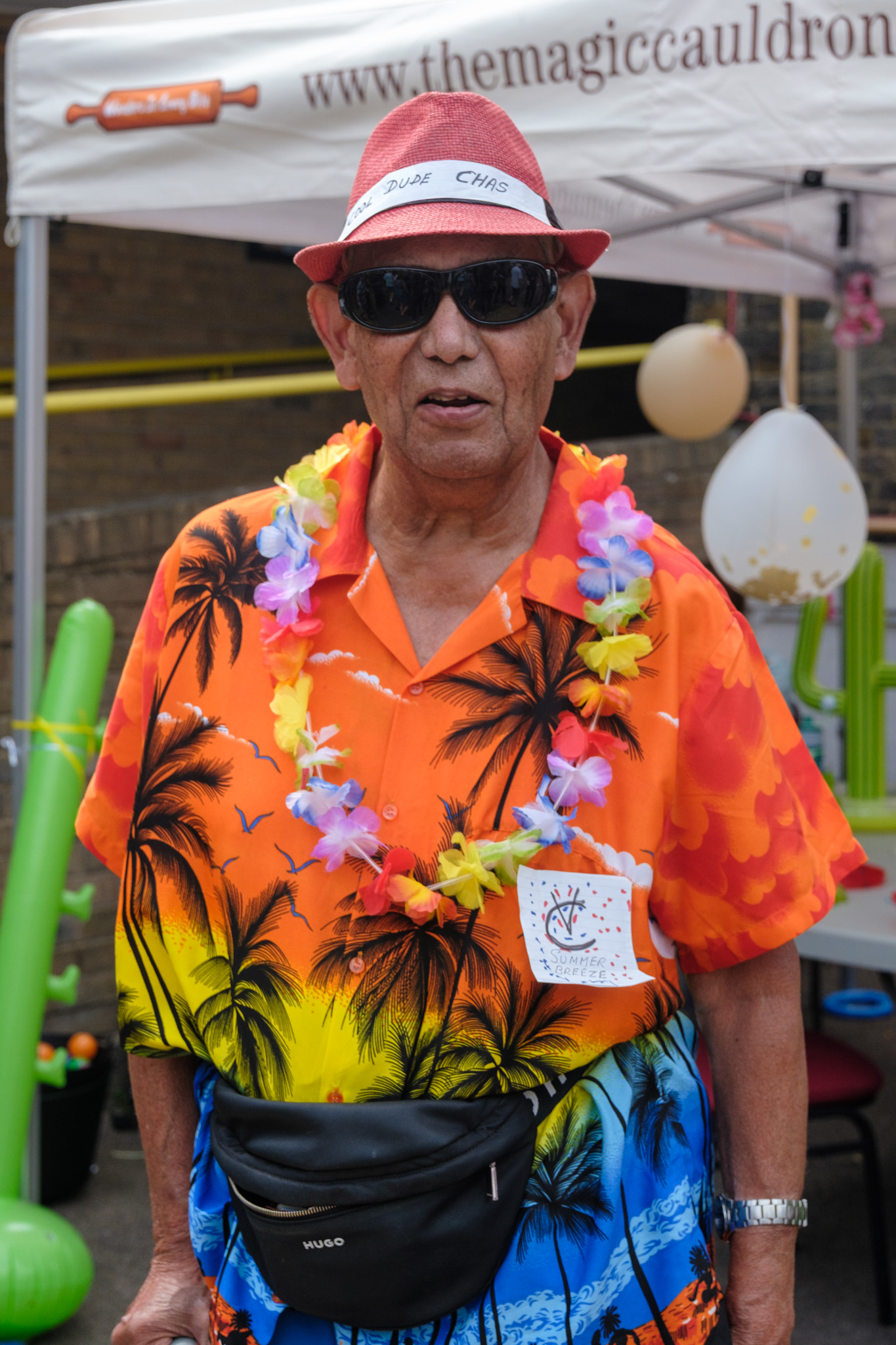 A guest dressed for the summer theme in a bright tropical shirt, sunglasses, hat and flower garland.