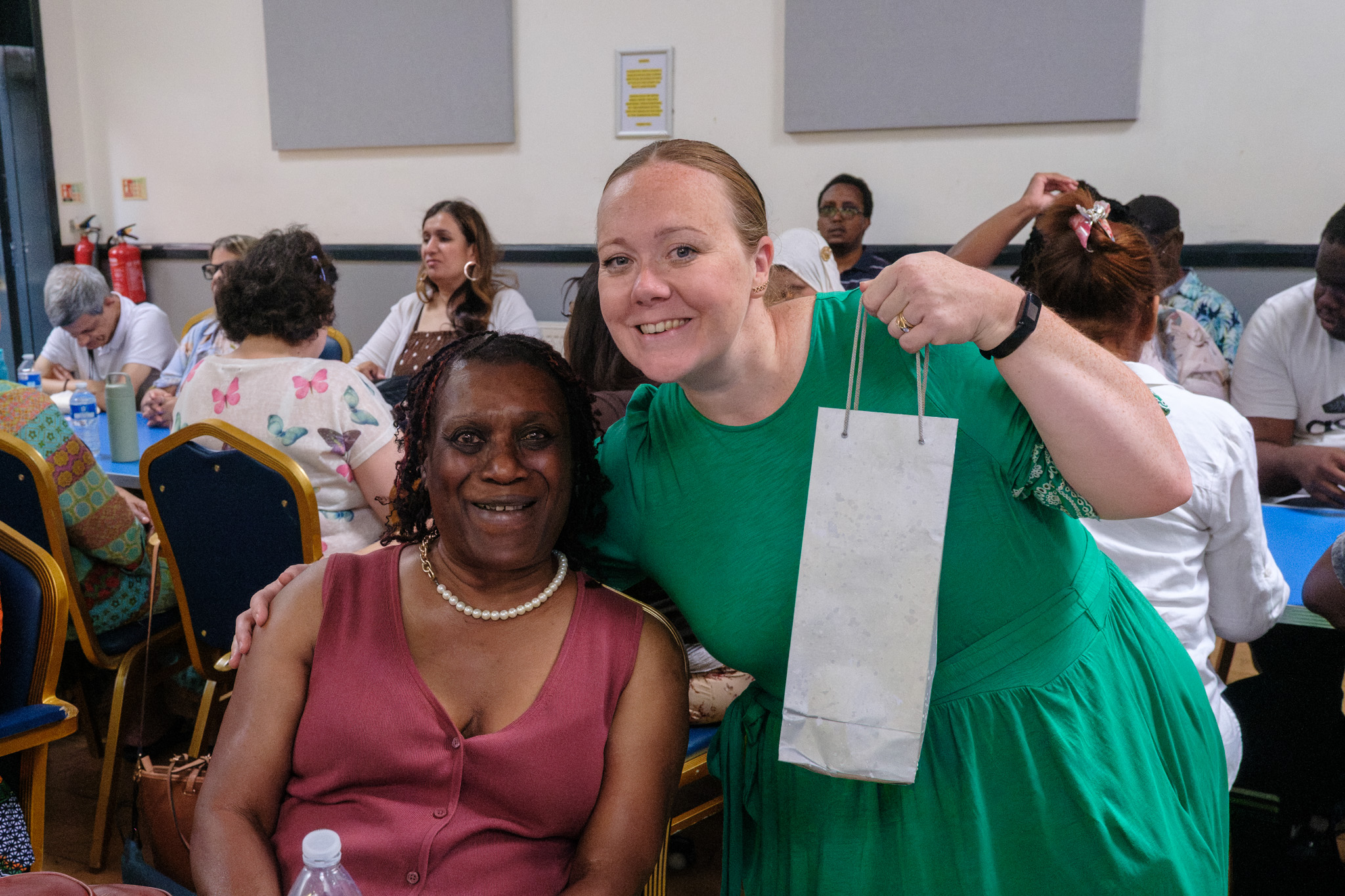 A Croydon Vision representative presenting a gift bag to a smiling guest.