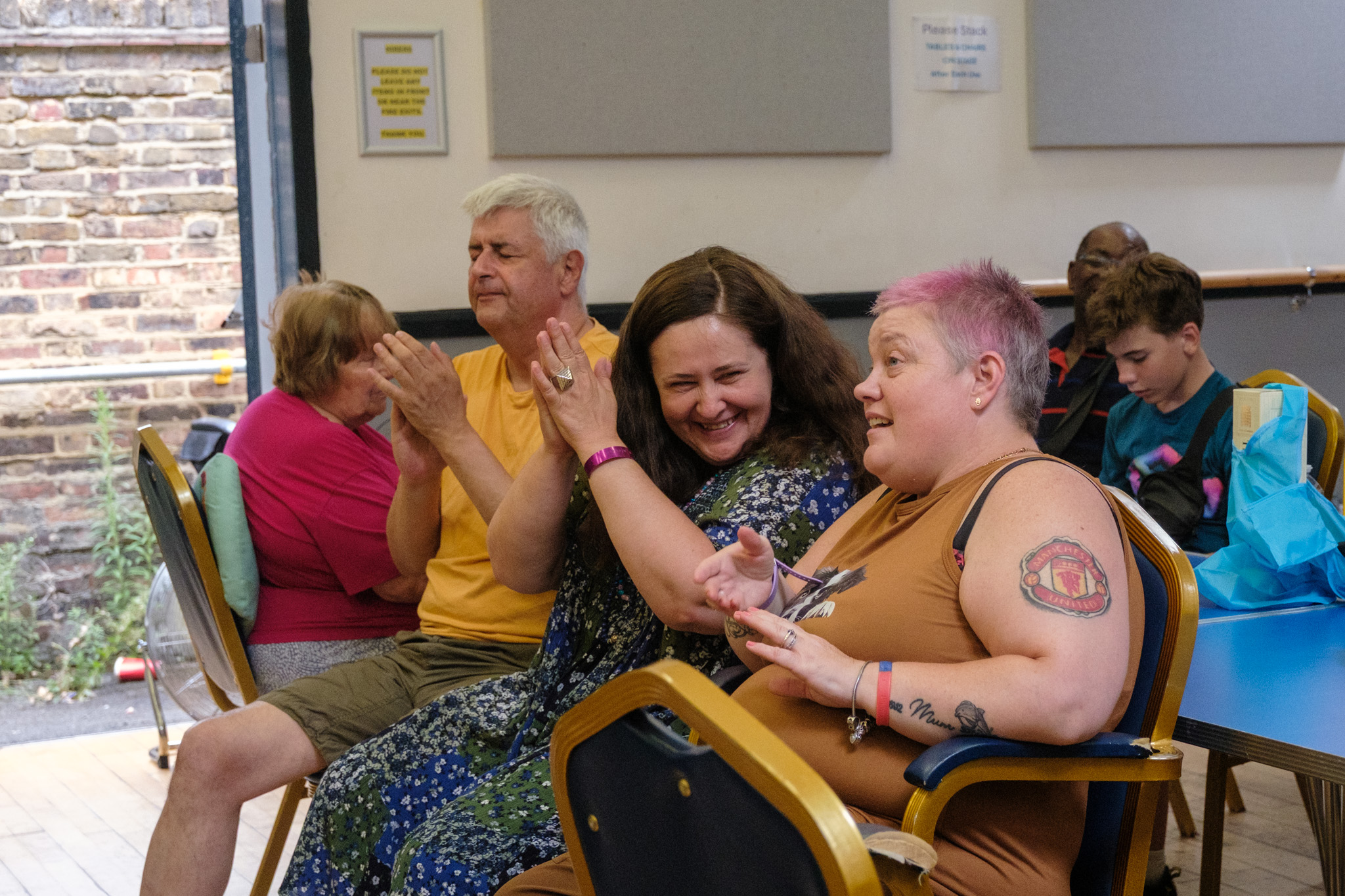 Guests smiling, clapping and chatting while watching the Summer BBQ entertainment.